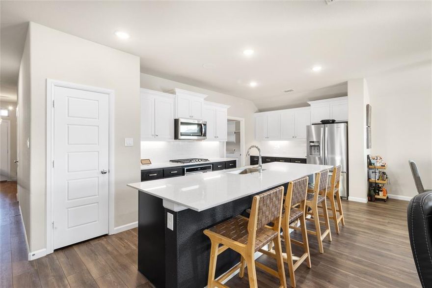 No PID tax in this move-in ready 3-bedroom, 2-bath home on a north-facing lot in Goodland at Prairie Ridge. The north-facing orientation helps reduce summer heat exposure and supports more consistent indoor comfort. Open-concept layout is anchored by a well-appointed kitchen featuring shaker cabinetry, granite surfaces, a gas cooktop, and a seated island ideal for everyday use or entertaining. The primary suite includes dual vanities and a glass-enclosed shower. A tankless water heater and full sprinkler system are already installed, and the family room features built-in surround sound speakers perfect for gameday and movie nights. Oversized laundry room doubles as a home office or additional workspace. Community amenities include a resort-style pool, splash pad, playgrounds, stocked ponds, and over 15 miles of hike-and-bike trails. Zoned to Midlothian ISD with Vitovsky Elementary, Frank Seale Middle School, and Midlothian High School. Approximately 30 minutes to Downtown Dallas via Hwy 67, with convenient access to Methodist Midlothian Medical Center and the Google Data Center. No PID means significantly lower monthly costs compared to nearby new construction. Schedule a private tour to experience it firsthand.