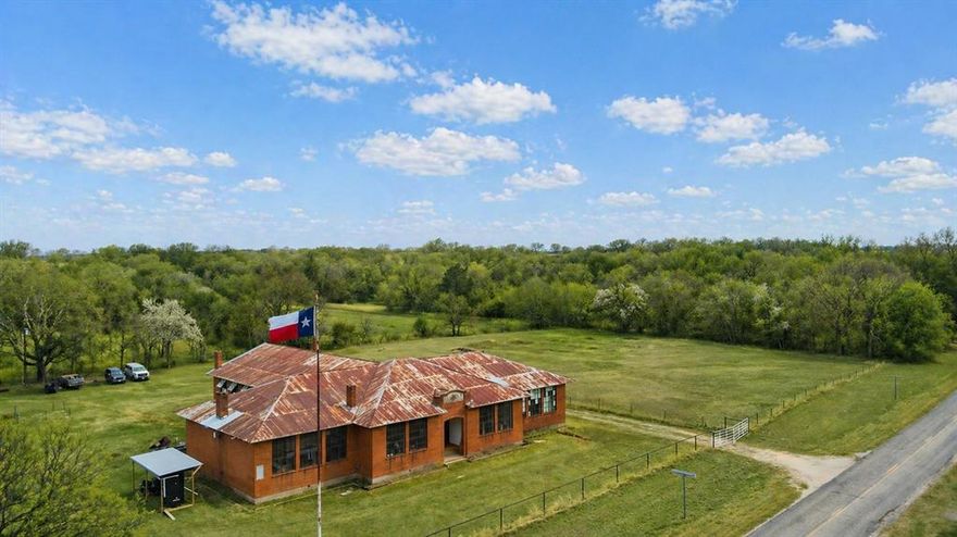 Designed by renowned Texas Architecture firm Voelcker & Dixon, the 7,000 square foot 1924 Spanish Fort High School is a testament to building practices that have stood the test of time. From its double brick walls, inch-thick plaster, vertical grain heartwood pine floors, this building is solid and ready for its next life. The fully fenced 2.6 acre property is nestled in the North Texas Hill Country and within thirty minutes Saint Jo, Nocona, three different wineries, and Red River Station concert venue. Several events throughout the year bring in thousands of tourists from across the region. With six classrooms ranging from 400-500 square feet and 2, 400 square foot auditorium and stage, this would make a great concert venue, wedding venue, boutique hotel or an additional winery as the property lies within the Texoma American Viticulture Area and soil samples have already been analyzed by Texas A&M. Underground 200 amp electric has been added with three 20 amp circuits and a small room and bathroom make it possible to stay overnight. Water is currently supplied by rain water catchment and high speed internet is active at the building. There is a well and septic but both systems should be considered in need of replacement. A copy of the original blueprints is available and will convey with the sale. Listing broker is the owner of the property.