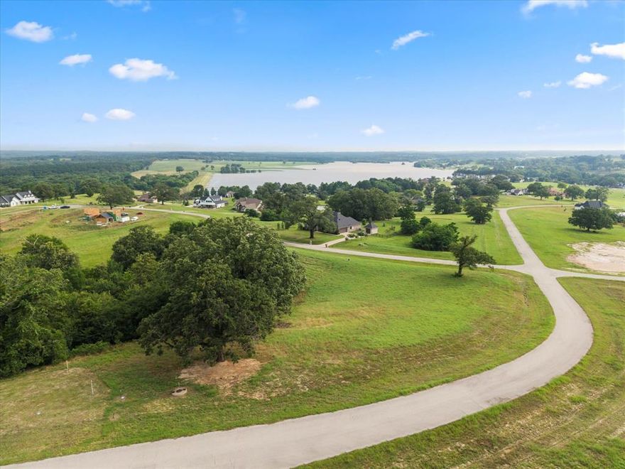 Enjoy sweeping views of the rolling countryside and tranquil lake below from this 1 acre homesite. This lot is an ideal canvas for your custom dream home. Located in the prestigious Waters Edge Ranch spanning over 2,150 acres, a gated community featuring just 376 exclusive homesites, this property provides the perfect blend of privacy, natural beauty, and upscale amenities. Enjoy access to a 328-acre private lake, fully stocked and complete with a boat ramp, ideal for fishing and peaceful days on the water. Community amenities include a resort-style swimming pool, a scenic lakeside pavilion, and a pickleball court—perfect for recreation and relaxation. For added convenience, residents also have access to an RV campground within the community. Whether you’re looking to build a full-time residence or a weekend retreat, Waters Edge Ranch offers a rare opportunity to embrace luxury, leisure, and nature all in one.