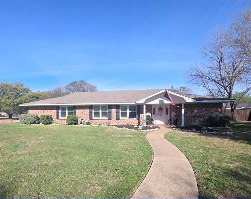 AWESOME HOME WITH TONS OF UPDATES AND GREAT LOCATION IN MEXIA ISD! This beautifully updated 3 Bedroom, 2 Bath brick, corner lot home offers an abundance of space and versatility with multiple living areas, including a formal living room, cozy den and a spacious Game room - perfect for entertaining or relaxing.
The inviting Entry hall leads to the open-concept Formal Dining Room and Formal Living Room area flows seamlessly into the Den which features a charming fireplace, built-in bookcases and a warm, inviting atmosphere. The Kitchen features granite countertops, nice appliances, large walk-in pantry, and a bright breakfast area which offers a great view to the peaceful backyard. Besides a Formal Living Room and a Den, the home also offers a 3rd living area - a large Game Room. This room is perfect for the kids to hang out on a sectional sofa and watch movies or add a pool table for family fun. The Primary Bedroom is spacious enough for a King sized bed and nightstands. You will also love the double closets and ensuite bath with double vanity. The secondary bedrooms have a Jack n Jill bath that also opens to the hallway for Guests to access.
Outside you will find a new extra large concrete patio with new metal awning. Sit outside and watch your favorite sports team while hosting a BBQ with family and friends as the kids play in the extra large backyard with privacy fence. Additional highlights include a 2 car garage with tons of storage and shelving. 
This lovely home has been well maintained and includes recent updates of fresh paint, new vinyl clad windows throughout with custom plantation shutters, and reputable foundation work with a Lifetime transferrable warranty. 
Schedule to see this home today! You will instantly fall in love!