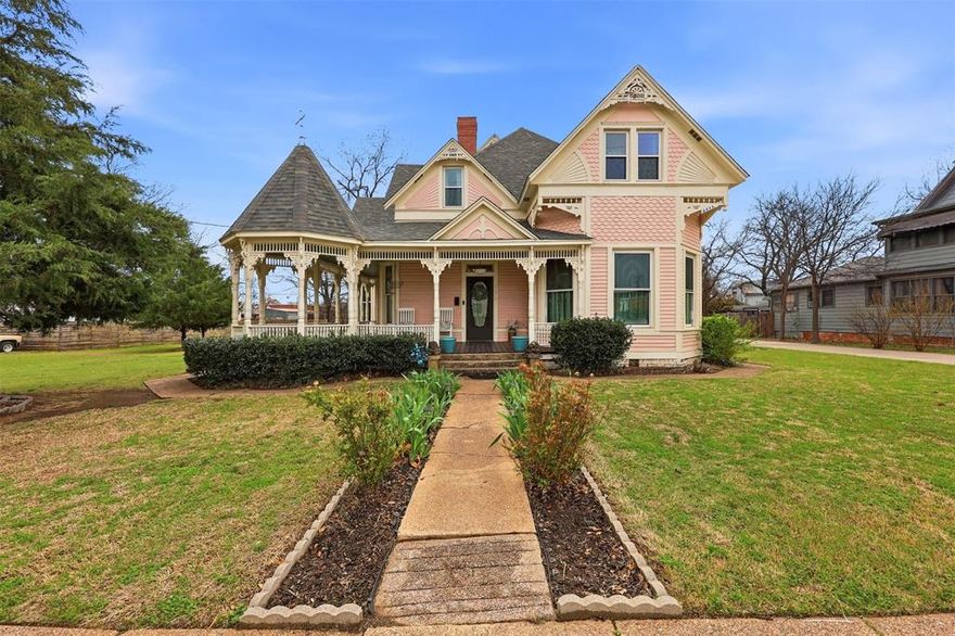 One of Bowie’s most recognizable historic homes, the former John Hill Matthews House, offers timeless Victorian charm on over half an acre in the heart of town. From the inviting wraparound porch to the original architectural details inside, this home captures character and craftsmanship that is hard to find today.

Inside you will find beautiful hardwood floors, detailed moldings, antique light fixtures, and multiple living spaces filled with natural light. The spacious kitchen includes a large pantry and connects to a bright breakfast room that is perfect for everyday meals or gathering with family and friends.

The downstairs primary suite offers a comfortable private retreat with its own sitting area, fireplace, ensuite bathroom, roomy closets, and convenient access to the utility room. Upstairs you will find five additional bedrooms with classic details including transom windows and tall door frames, along with two full bathrooms and extra space that works well for reading, games, or relaxing.

Outside the half acre property provides shaded areas for gathering, open green lawn space, and room to enjoy outdoor living. A 20 x 40 detached garage offers plenty of space for parking and storage, while the original carriage house remains on the property and offers exciting possibilities for restoration, guest space, a studio, or workshop.

Homes with this much history, space, and charm do not come along often. Come see what makes this Bowie property so special.