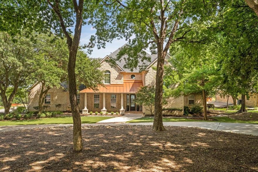 Located on an exclusive cul-de-sac with commanding lake views, this custom estate offers luxury lakefront living at its finest. With 4 bedrooms, 4.5 baths, set on 1.4 meticulously maintained acres, this home combines timeless craftsmanship with modern comfort for the discerning buyer. Inside, you’ll find hand-scraped hardwood floors, soaring ceilings, and a warm living area anchored by a stone fireplace and built-in wet bar, perfect for both executive entertaining and cozy evenings in. Expansive windows frame breathtaking water views from the living room, kitchen, and breakfast area, filling the home with natural light and serenity. The sunroom retreat offers a peaceful place to begin or end the day, while the gourmet kitchen features a gas stove, center island, breakfast bar, and a spacious walk-in pantry, ideal for hosting or everyday living. The primary suite retreat is a private sanctuary with a spa-like bath that includes a freestanding soaking tub, oversized shower, dual vanities, and a spacious walk-in closet complemented by a flexible area perfect for a dressing room, workout space, or more. A mezzanine office with built-ins offers a quiet, elevated workspace ideal for working from home or creative pursuits. Upstairs, newly installed carpet, spacious secondary bedrooms, and a versatile game room offer privacy and flexibility for guests or family. Thoughtful storage throughout the home supports a clutter-free, elevated lifestyle. Step outside to your outdoor oasis featuring a sparkling pool, hot tub, and a fully equipped 446 Sq Ft pool house with a full bath, ideal for guests or entertaining. The covered patio, complete with a second fireplace and uninterrupted water views, creates the perfect setting for year-round enjoyment. This is a rare opportunity to own one of the area’s premier lakefront luxury homes, available.