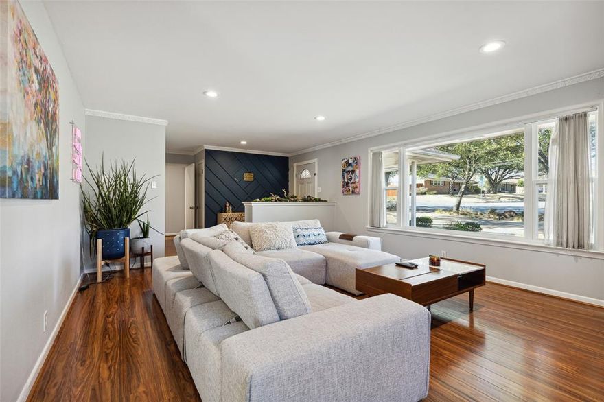 Stylish East Kessler home perched on a hill framed by mature trees and front circle drive. Many recent updates since 2016 include roof & HVAC, newly installed & refinished hardwood floors, updated wiring, added insulation, double-pane windows, recessed LED lighting, & contemporary bathroom updates. Two large living areas provide generous entertaining off the open-concept kitchen featuring double convection ovens, granite counters, beverage cooler, island and breakfast bar. Kitchen opens to comfortable den with fireplace and enjoys beautiful views of the deep lush backyard through a large picture window. Large bedrooms feature dual walk-in closets. Plenty of parking with circle drive and electric iron gate down to both a 1-car garage and additional carport. Conveniently located to Sylvan-Thirty, Bishop Arts, and only 3 miles to the center of Downtown Dallas.