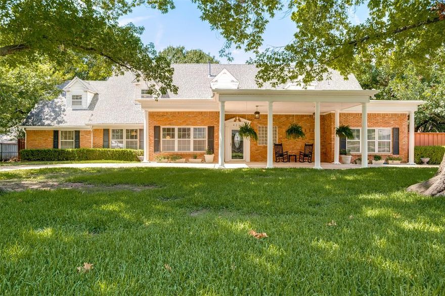 With all the charm of a 2-story, red brick Colonial-style home featuring white columns under a tall porte cochere, this 4,003 square foot home checks all the boxes! Boasting 5 bedrooms. 4 full baths & 2 half baths, the floor plan provides lots of flexibility. 2 spacious living areas are downstairs, accessing the beautifully updated kitchen with floor to ceiling cabinets, granite counters, & a full suite of stainless steel appliances. The inviting den provides beautiful builtin shelving & a handsome fireplace, with a door to the back patio. The ensuite primary bedroom & a second ensuite bedroom are on the 1st floor, with 3 bedrooms & 2 baths on the 2nd floor. At the top of the stairs is a game room available to 2 connecting bedrooms that share a large updated bathroom, with a 5th bedroom that accesses another updated full bath! At the end of the hall is a large office space that opens to a cozy media room! Surrounded by grassy lawns & tall trees in front and back, there is a captivating white back house with all utilities, & just enough space for an overnight guest! A floor plan & survey are available.