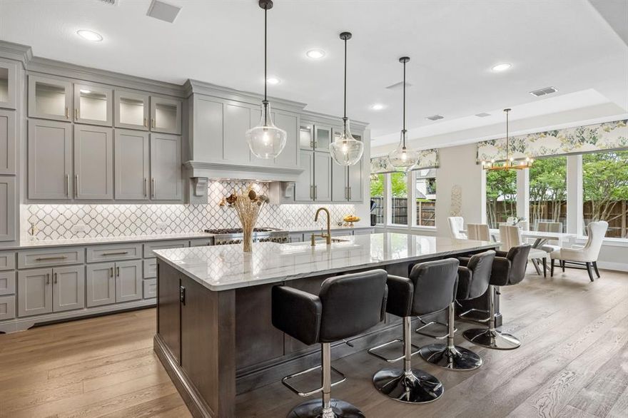 This stunning custom built home that blends refined design with functionality in one of Dallas’ most desirable ares. Thoughtfully designed with most living spaces on the main level, this home offers an ideal layout for both everyday living and elevated entertaining.
Inside, wide-plank wood floors, solid core doors, crown molding, and designer lighting set a sophisticated tone throughout. The private study features elegant wainscoting, stained cedar beams, and a striking chandelier, while the main living area is anchored by a dramatic floor-to-ceiling stone fireplace with cedar beam accents and seamless access to the outdoor living space.
The chef’s kitchen is both beautiful and highly functional, showcasing custom cabinetry, quartz and quartzite countertops, a marble backsplash, and an oversized alder island. Premium appliances include a 48-inch JennAir dual fuel range, built-in KitchenAid refrigerator, warming drawer, microwave, and custom vent hood, all complemented by a large walk-in pantry and under-cabinet lighting.
The main level includes the primary suite, a secondary bedroom, a media room, and a sunroom, while a spacious game room is located upstairs. The primary suite is a true retreat with cedar beam, a spa-inspired bath featuring dual vanities, a freestanding tub, and an expansive walk-in shower with dual rain head. Outdoor living is exceptional, with two rear covered porches and a fully equipped kitchen complete with honed granite countertops, EVO griddle, Memphis smoker, and ample storage. The oversized backyard offers plenty of room for a future pool and is enclosed by an 8-foot board-on-board cedar fence for added privacy. Additional highlights include dual laundry rooms, a full security system, atoms speakers in the media, tankless water heaters, plantation shutters, and an oversized three-car garage with epoxy flooring.
This is a rare opportunity to own a thoughtfully designed, move-in ready home with luxury finishes and an unbeatable layout.