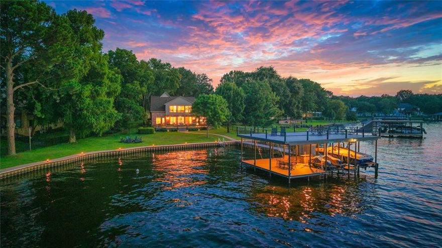 Situated on a stunning half-acre waterfront lot with an impressive 198 feet of shoreline, this expansive 5-bedroom, 3.5-bath home offers breathtaking open water views and deep water access in one of Cedar Creek Lake’s most desirable subdivisions. Perfect as a full-time residence, vacation retreat, or short-term rental, this home is designed for hosting and entertaining. Inside, the living room boasts luxury vinyl plank flooring, a gas fireplace, a wet bar, and panoramic views of the lake. The kitchen features granite countertops, a built-in refrigerator, and an abundance of cabinet and counter space, complemented by a cozy breakfast area and formal dining room ideal for holiday gatherings. The primary suite offers lake views, a spacious ensuite with double vanities, a soaking tub, walk-in shower, and a large walk-in closet, as well as a private waterside sitting area perfect for a home office or peaceful retreat. Upstairs includes three additional bedrooms, 2 more bathrooms, a generously sized bunk room with a second wet bar, and a large game room with expansive picture windows showcasing unobstructed water views. Outdoor living is elevated with a wraparound deck composite deck overlooking a beautifully landscaped yard, complete with a fire pit, hot tub, and a massive composite-deck 1337 sq. ft. boathouse featuring a boat slip, dual jet ski platform, covered sitting area, and a party deck with miles of open water vistas. Oversized 3 car garage accommodates 2 vehicles plus room for a golf cart and storing all those water toys. Circle drive and large driveway accommodates several vehicles. The home is sold fully furnished with limited exclusions, making it truly turnkey and ready for immediate enjoyment. Proven short-term rental history available.