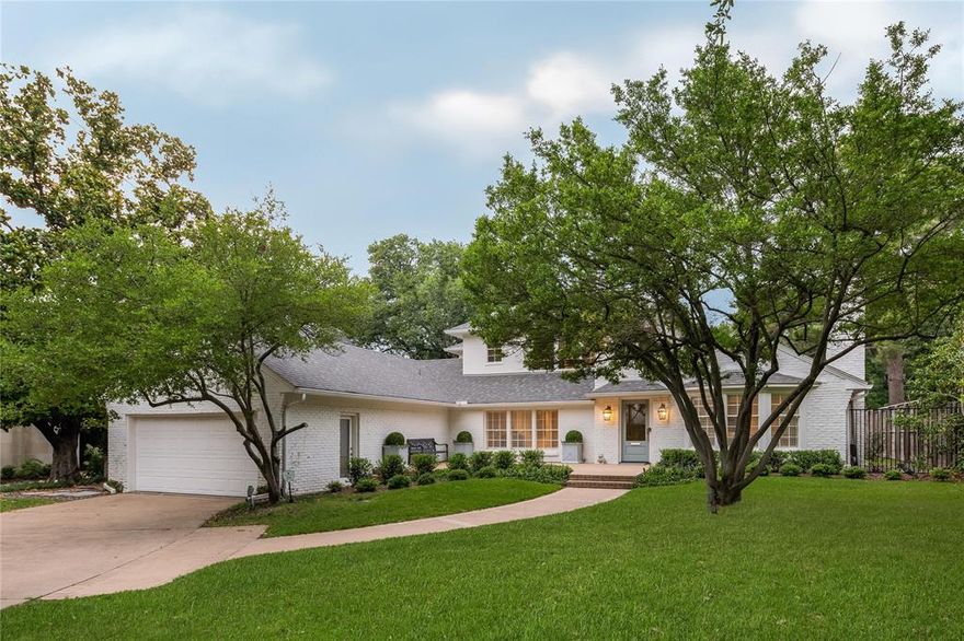 Lush landscaping, mature trees, and a sprawling grassed yard surround this stunning magazine worthy two-story home in Dallas's Greenway Parks. Inside, a bright, open flowing floor plan greets you with striking formals boasting warm fireplaces and ample windows, a study nook, and a spacious den. The gourmet kitchen features a vast island with seating for five, a gas stove, dual ovens, and ample storage. The peaceful primary suite hosts a sitting area, built-ins, a private patio, a spa-like ensuite with double sinks, an expansive seamless glass shower, and a walk-in closet. The main floor of this perfectly polished home is complete with a sophisticated half bathroom and a utility room. Upstairs, a nicely-appointed bedroom plus a second primary suite with a Juliet balcony, both with ensuite baths. Relax on the extensive open patio overlooking greenbelt views, swim in the sparkling pool and spa, or play in the faux grassed yard.