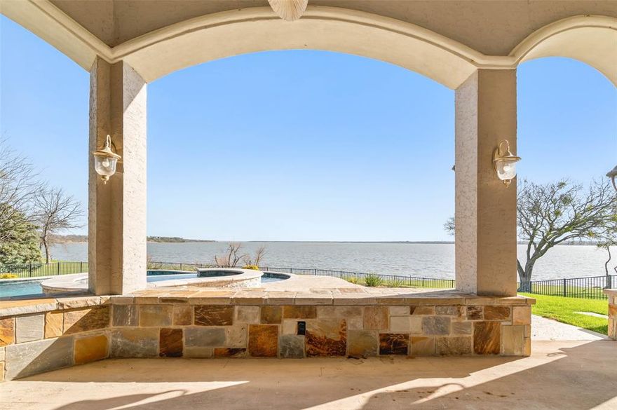 THE MOST BREATHTAKING VIEWS ON LAKE LEWISVILLE. Poised on 1.4 pristine acres, this exceptional 6,203 sq ft waterfront estate is a rare offering—pairing timeless architecture with refined modern luxury. Designed to impress and crafted for comfort, the residence welcomes you with meticulously manicured grounds and an elegant, commanding façade.

Inside, soaring ceilings, expansive windows, and thoughtfully curated finishes create an atmosphere of light, volume, and sophistication. Generously scaled living and entertaining spaces flow seamlessly throughout the home, framing uninterrupted lake views at every opportunity.

The gourmet kitchen serves as the home’s centerpiece—featuring premium appliances, custom cabinetry, and an oversized island ideal for culinary pursuits and gathering with guests. Just beyond, the warm and inviting family room with its stately fireplace provides the perfect setting for relaxed living.

Offering five luxurious bedrooms and five beautifully appointed bathrooms, the home is designed for both privacy and versatility. The primary suite is a serene retreat complete with a spa-inspired bath and expansive dressing area.

Outdoors, the waterfront grounds elevate lakefront living—showcasing wide open vistas, resort-style spaces, and endless potential for entertaining, recreation, or quiet reflection. Whether hosting unforgettable evenings by the water, enhancing the outdoor oasis, or enjoying the natural beauty that surrounds you, this property invites a lifestyle without compromise.

Situated in the desirable community of Cross Roads, 5401 W Oak Shores Dr blends tranquility with convenience—delivering an extraordinary opportunity to own one of Lake Lewisville’s premier estates.