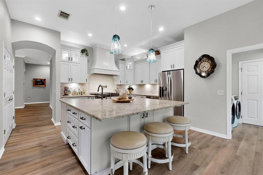 Welcome to this stunning stucco and stone Trova, beautifully remodeled and perfectly situated on a lush greenbelt with walking path access. Step inside to find luxury vinyl plank flooring flowing throughout the entire home, creating a seamless, modern feel.

The showstopper chef’s kitchen is loaded with high-end upgrades: a custom-designed island with leathered granite, farmhouse sink, instant hot water, trash compactor, pull-out recycling bins, generous storage, and seating. The Wolf double oven gas range is framed by a mother-of-pearl and marble tile backsplash and topped off with a convenient pot filler. The under-counter microwave opens with an automatic drawer for easy access. The bay-windowed breakfast nook is complete with a wet bar, wine fridge, and a second instant hot water tap.

The spacious primary suite offers a bay window, stylish fandelier, and an ensuite featuring a frameless glass shower with built-in seating. The second bedroom offers your guests privacy with extra storage. A dedicated office with a corner entry includes a custom built-in double desk, ideal for his and hers workspaces.

The oversized garage with golf cart bay boasts durable polyaspartic flooring and room for a workbench. Out back, the covered patio and outdoor kitchen create the perfect spot to unwind or entertain, all while soaking in peaceful greenbelt views.

Bonus: Washer, dryer, kitchen fridge, and garage fridge are all included—just move right in!