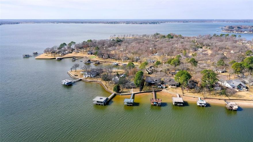 Spectacular one story ranch style lakefront home situated on wooded cul-de-sac lot with a ton of parking in highly sought after Enchanted Oaks at Cedar Creek Lake.  Enchanted Oaks is where only site-built homes are permitted to preserve value and appeal. The residence enjoy access to the community pool, playground, dog park, boat launch and boat storage areas.  This home features 3 spacious bedrooms one of which is a bunk room that sleeps 6, 2.5 baths, a flex space, and 3 living areas including large game room with wood beamed vaulted ceilings, custom built-ins and Plantation Shutters.  The family room offers a stone WBFP and an effortlessly flows to the second living area with an abundance of windows overlooking open water and the huge wrap around deck with gazebo.  Enjoy endless breathtaking views of the lake with eastern facing morning sunrise, firepit, and recently updated boat dock with party deck including boat lift plus PWC lift and covered porch area!  The opportunities are endless would make a perfect primary home, second home, vacation home that is great for entertaining both family and friends.  Many recent updates including roof in 2025, dock tune up 2025-2026, steel retaining wall 2020, landscaping 2024.  Please see Transaction Desk for details and receipts.