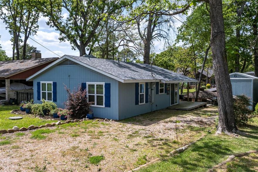 Delightful, fully furnished lake house that has everything you need to enjoy lake living!  Open kitchen and living, wood burning fireplace, vaulted ceilings with wood beams create beauty and space. Outside is a nice, covered deck, a cement patio, cement sidewalk down to the water. The boathouse has electric lift and recently added cradle, new ladder to get in and out of the water. The wide boathouse deck is great for fishing, swimming and sitting by the water.  At full lake level, the channel is about 7' deep and even when lower, boats can still get in and out. Roof was recently replaced, electrical updated including new panel, new chimney cap and flashing, recent exterior paint. Over the last few years, new windows and doors, HVAC. Established yard with French drains on both sides, landscaping and large shade trees and storage building. Sewer converted from septic to public sewer. Beautiful Cedar Creek Lake is only an hour from Dallas, Tx. and is a favorite's for both fishing and recreational activities. Owner Financing available.