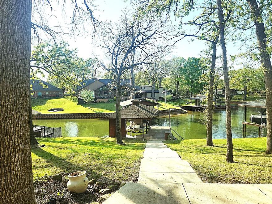 This turnkey, fully furnished home has everything you need to enjoy lake life!  Open kitchen and living, wood burning fireplace, vaulted ceilings with wood beams create beauty and space. Outside is a nice, covered deck, a cement patio, cement sidewalk down to the water. The boathouse has electric lift and recently added cradle, new ladder to get in and out of the water. The wide boathouse deck is great for fishing, swimming and sitting by the water.  At full lake level, the channel is about 7' deep and even when lower, boats can still get in and out. Roof was recently replaced, electrical updated including new panel, new chimney cap and flashing, recent exterior paint. Over the last few years, new windows and doors, HVAC. Established yard with French drains on both sides, landscaping and large shade trees and storage building. Sewer converted from septic to public sewer. Beautiful Cedar Creek Lake is only an hour from Dallas, Tx. and is a favorite's for both fishing and recreational activities. out with ease.