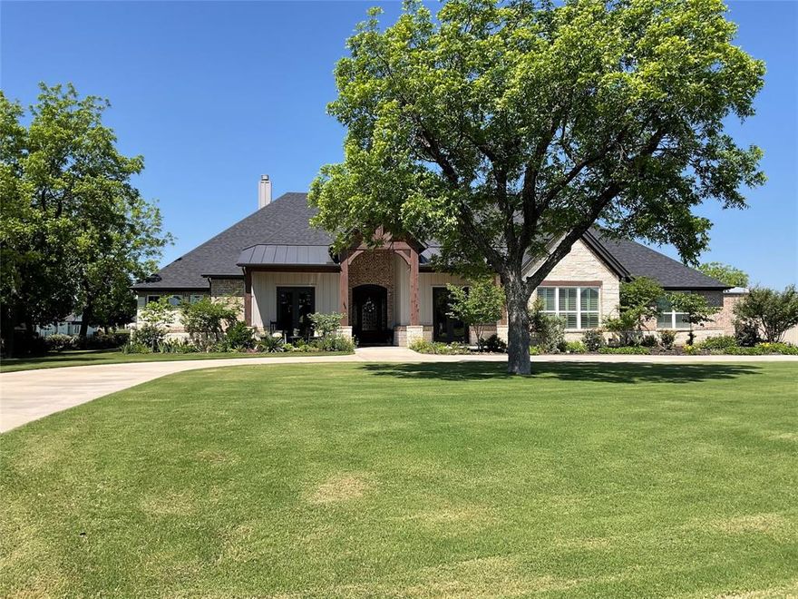 Better than new, full custom home located in the highly desired The Landings Airpark (FAA Identifier 66TE). This thoughtfully designed residence offers an open-concept layout with hand-scraped, nail-down hardwood flooring throughout and no carpet or tile. Architectural details include high-beam ceilings, 8 ft doors, hand-troweled walls, and extensive trim and crown molding. Double French doors open to both the front sitting porch and the rear patio, creating comfortable indoor-outdoor flow. Piano room can easily be 4th bedroom. Additional features include plantation shutters, solid wood custom barn doors at the office and primary suite, dovetail soft-close drawers, and granite and marble countertops throughout the home. Includes a 1-year-old Class 4 roof, dual upgraded Trane HVAC systems, a ventless gas fireplace with auto-light, and an extra-deep 4-car garage with custom insulated doors. The kitchen is well equipped with stainless KitchenAid appliances, a 48 inch Wolf rangetop with griddle, pot filler, apron sink, and a remote-controlled range hood, along with a large pantry, butler’s pantry with wine cooler, and extensive cabinetry and storage. The oversized primary suite features a Dutch vaulted ceiling, a spacious custom bath with dome ceiling, and a finished walk-in closet. Bathrooms include four walk-in showers, three of which are doorless, with tile extending from floor to barrel ceiling. Outdoor living is highlighted by an 18x38 PebbleTec saltwater pool, Intelli-Connect controlled, surrounded by an oversized patio with outdoor kitchen, wood-burning gas fireplace, motorized retractable screens, and polyurea-coated flooring, providing a comfortable space for everyday use and entertaining. The 60x60 hangar offers excellent utility with a 54 ft Higher Power door, polyurea-coated floors, 14 ft Big Ass fan, 12 ft high siding with loft storage, a bathroom, 50-amp RV plug, and an RV door, making it suitable for aircraft storage, RV use, or additional workspace.