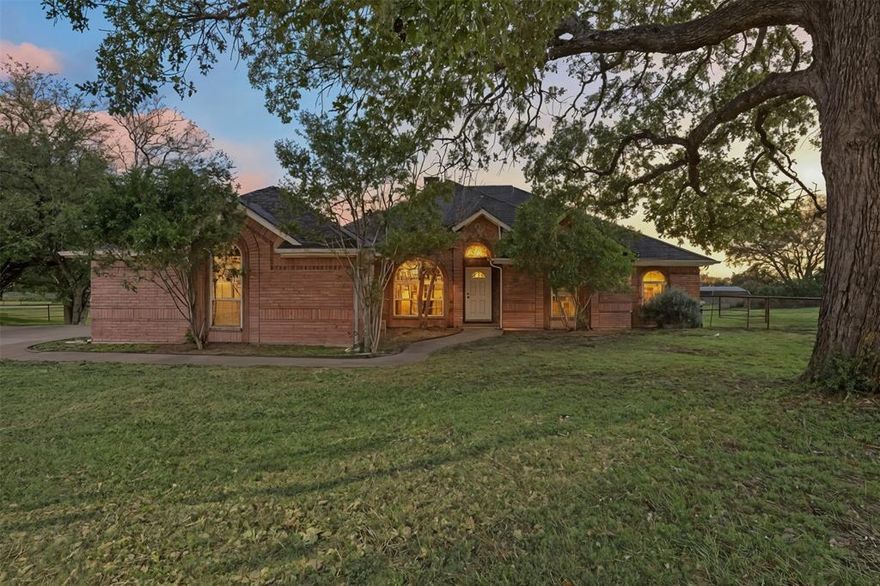 GORGEOUS, almost 2 acre country retreat just outside the City Limits! NO CITY TAXES! Beautifully updated 4-bedroom, 2-bath home situated on an acreage, corner lot in one of Granbury’s most sought-after areas! This home features the perfect layout with raised, custom ceilings, recessed lighting & abundant natural light. The remodeled kitchen features granite countertops with tumbled marble backsplash, raised granite breakfast bar, stainless steel appliances including induction double oven, under cabinet lighting & stylish 2-way wood-burning fireplace. Formal dining plus breakfast nook in kitchen. Diamond pattern tile flooring throughout. Built-in hutch, custom cabinetry & formal living plus family room. Spacious primary bedroom with upgraded primary bathroom featuring granite countertop with double sinks, walk-in tile shower & separate jetted tub with tile surround & wood-burning fireplace plus walk-in closet. This home offers a newer roof, HVAC which is serviced annually & a septic that was pumped in the last couple of years. 2 car garage with workbench. The outside offers ample parking on extended concrete pad driveway, covered porch, covered concrete patio with extended, uncovered concrete patio perfect for entertaining! Located at the rear of the property is a 40x 40 workshop with horse stalls plus excess land fenced in pipe fencing. The country feel within minutes from all things city can't be beat!
