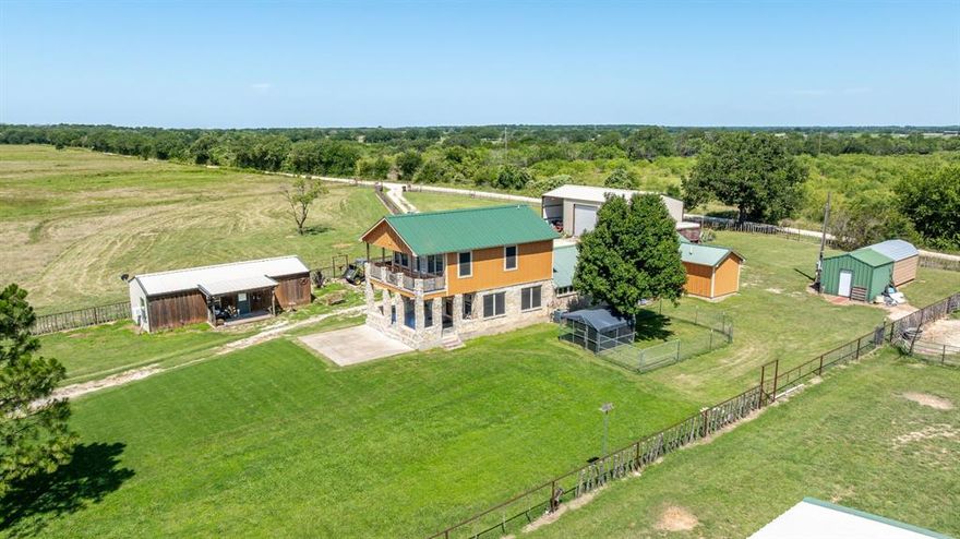 Discover 26 ag-exempt acres in the countryside of Hico, Texas, located in beautiful Bosque County. This exceptional property features a custom-built home, a large shop, and a separate equipment barn, making it perfect for those seeking a peaceful rural lifestyle with modern comforts.

The main house offers 2 bedrooms and 3 baths, showcasing thoughtful craftsmanship throughout. Highlights include authentic stonework in the kitchen, wood-vaulted ceilings, tin ceilings in the living room, tile flooring, and large windows that provide scenic views of the landscape. The open-concept layout connects the kitchen, dining, and living areas.

On the main floor, you will find the primary suite, which includes a private bath and an attached laundry room with additional closet space. Upstairs, a private second suite features hardwood floors, a walk-in closet, a full bathroom, and a balcony that overlooks the property.

The property is adorned with shaded oak trees and includes a large stock tank. It is fully fenced, making it ideal for livestock, recreation, or simply enjoying nature. For guests or those staying for an extended period, a charming 2 bedroom guest house with a kitchenette is available, offering extra space and privacy.

Improvements: The property features a deep water well with an updated pressure tank and water softener. There are two large equipment barns, both equipped with electricity and 220-volt service. The center section of one of the barns has been insulated and includes a roll-up door with concrete flooring, making it suitable for a workshop area.

Located just minutes from the vibrant town of Hico—known for its restaurants, boutiques, and live music—this property presents a blend of country living and small-town charm.