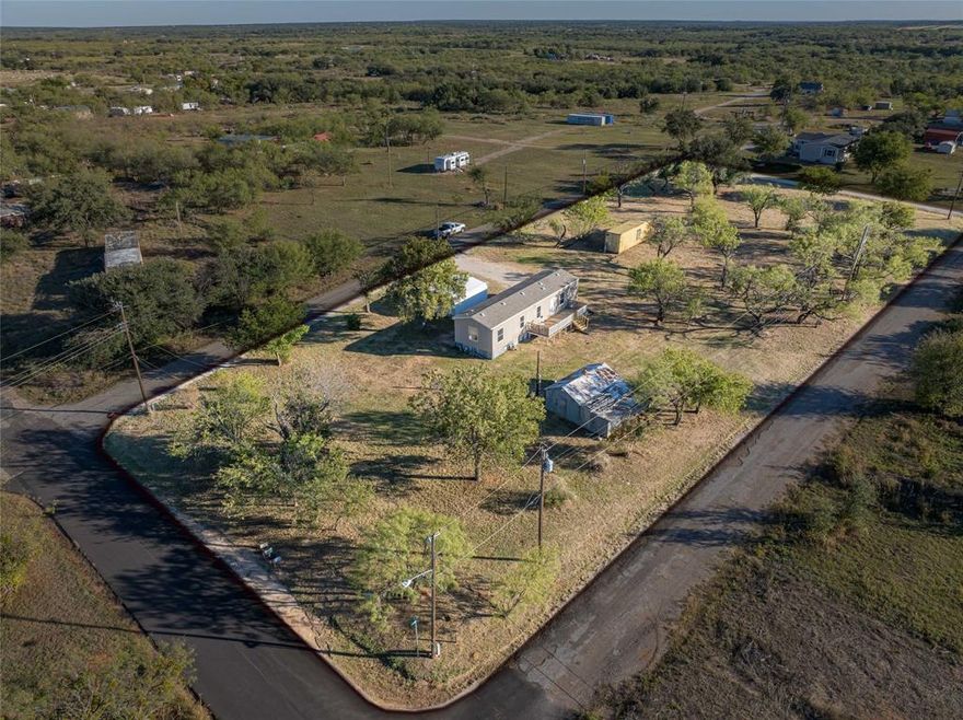 Affordable & Move-In Ready!!! Updated 2-bedroom, 2-bath 2015 manufactured home on an entire block totaling nearly an acre. Features an open floor plan, central heat & air, fresh paint, new carpet, and all-electric utilities. Kitchen includes stove, dishwasher, refrigerator, plus washer & dryer. Primary suite offers a private bath with walk-in closet. Relax on the back deck and enjoy peaceful evenings. Two storage sheds provide plenty of extra space. Owner financing available! Great value for first-time buyers, investors, or downsizers. Buyer and or buyer's agent to verify all information.