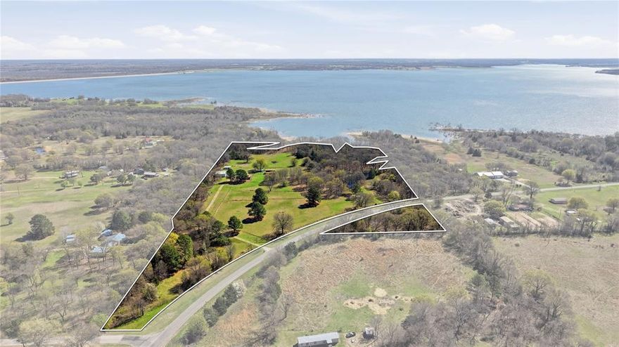 Lakefront acreage on Bois D’Arc Lake is rare, but nearly 22 acres with room to build your dream retreat is almost unheard of. This one-of-a-kind property offers the perfect setting for an executive retreat, private family compound, or future lakefront development with large lots. A charming 1-bedroom, 1-bathroom barndominium with attached shop is already in place, providing a comfortable space to live or enjoy weekend escapes while you design and build your dream home overlooking the lake. The covered deck offers beautiful lake views, and with nearly 22 acres to work with, there are endless locations to build a custom lake home while still preserving incredible water views. The acreage also provides ample space to add guest houses, shops, or additional cabins to create the ultimate private lake retreat or short-term rental getaway. Approximately 1 acre sits on the west side of Old 1396, offering excellent flexibility for future investment or additional uses, while the majority of the property lies on the east side of the road with direct lake access. The land is currently set up as a hobby farm and includes a pond, a barn with livestock stalls, an equipment barn for agricultural storage, a chicken coop, and a separate studio space ideal for a hobby room or storage. The property also has cross fenced paddocks for animal grazing rotations. The property is currently Ag Exempt through honey bee production, helping keep property taxes low. Mature trees, abundant wildlife, and the peaceful setting create a truly special environment rarely available on Bois D’Arc Lake. The public boat ramp is just minutes down the road on Old 1396. Whether you’re envisioning a private lakefront estate, executive getaway, or recreational retreat, this property offers exceptional potential in an extraordinary lake front location.