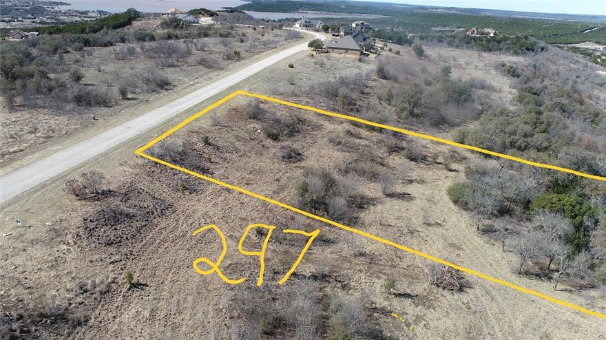 This two acre lot has a wide expanse of road frontage and several choices for house placement.  RECENTLY CLEANED UP for ease of waking and understanding the topography of the property.  A variety of large mature trees pepper this property giving it shade, trails, privacy, and charm. The backside of this lot could be a fun place to create your own trails and private oasis looking into the canyon. The two acre lot 296 is also for sale next to this lot MLS # 21163044.  That would give you 4 acres in which to enjoy the sights and sounds of nature all around including deer, roadrunner, turkeys, owls, and a myriad of other Texas birds. The stars are brighter out here at The Hills! You will also enjoy the use of the upscale amenities including the gorgeous community clubhouse infinity swimming pool, community lake cabin, boat dock, boat storage, and watercraft launch area. Spacious fitness center is located inside the community clubhouse with commercial grade equipment, TV, and many large windows to let the beauty of the surrounding area been enjoyed while you are working out.  Annual Mardi Gras parade is Saturday March 7th.  Great time to come on out and walk the property!