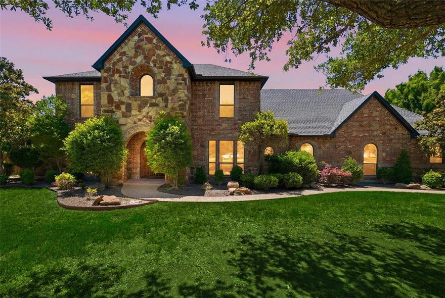 Tucked away on 3+ beautiful acres in one of Waxahachie’s most desirable areas, this extraordinary custom estate offers the perfect balance of luxury, privacy, space, and comfort. This home was thoughtfully designed for both entertaining and functional living, featuring 4 spacious bedrooms, 4 expansive living areas, and 2 dining spaces surrounded by mature trees and breathtaking outdoor amenities. From the moment you arrive, the striking stone and brick exterior, and oversized driveway create an unforgettable first impression. Inside, the home is filled with warmth and character, offering soaring ceilings, rich wood trim, abundant natural light, and an inviting layout that effortlessly flows from room to room. The beautifully updated kitchen is the heart of the home with extensive custom cabinetry, beautiful countertops, large center island, gas cooktop, double ovens, designer backsplash, and generous prep space overlooking the backyard oasis. The main living area showcases a stunning fireplace and walls of windows that frame peaceful views of the property. Upstairs, multiple flex spaces provide endless possibilities including a game room, media room, workout area, or secondary living areas ideal for multigenerational living. The oversized primary suite offers a true retreat with spa-inspired bathroom, dual vanities, soaking tub, walk-in shower, and spacious closet. Step outside and experience what truly sets this property apart. The resort-style backyard was designed for entertaining with a sparkling pool and spa, slide, outdoor kitchen, covered cabana, and multiple patio spaces surrounded by mature shade trees creating a private park-like setting. The sprawling acreage also offers room to roam, play, garden, or simply enjoy the peace rarely found this close to town. Combining timeless craftsmanship, impressive square footage, exceptional outdoor living, and a highly sought after Waxahachie location, this is the kind of property that rarely comes available.