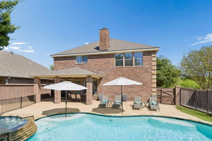 NEW HVAC UPSTAIRS JUST INSTALLED! This custom home is a true standout in La Bandera at Team Ranch, offering an impressive 3,236sf, five bedrooms plus a private, heated pool secured by its own gated entry. From the moment you step into the grand foyer with soaring ceilings, you’re welcomed by refined details including double crown molding and freshly painted interiors, new carpeting and updated lighting in many rooms.

Designed with comfort and versatility in mind, the home offers space for every lifestyle. The formal dining room, currently styled as a study, sits just off the entry. The beautifully appointed kitchen features freshly painted cabinetry, granite countertops, large island, stainless steel appliances,  walk-in pantry, and a built-in wine rack, all overlooking the living area and spacious breakfast nook with bar seating.

The expansive living area offers exceptional flexibility for a variety of furniture arrangements, anchored by a cozy wood-burning fireplace and a striking wall of windows that showcase views of the sparkling backyard pool. Just around the corner, you’ll find a downstairs bedroom, half bath and a utility room thoughtfully equipped with a sink.

Upstairs, are three secondary bedrooms, each with walk-in closets, along with thoughtfully designed Jack-and-Jill bath. A generously sized media room offers additional space for relaxation or entertainment. The primary suite is a true retreat, featuring a sitting area and a spa-inspired ensuite with split vanities and a separate shower.

Step outside into your own private retreat, where a meticulously maintained heated saltwater pool takes center stage, complete with a cascading rock waterfall and spa for a true resort-style experience. The covered patio seamlessly extends your living space, offering ample room for both relaxed lounging and alfresco dining. A separate outdoor kitchen with a built-in grill enhances the setting, while the greenspace includes a fenced area ideal for gardening.
