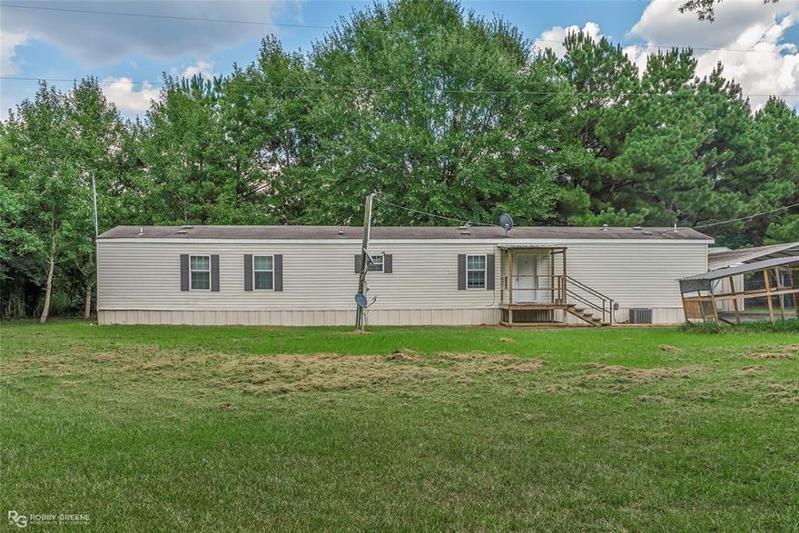 Welcome home! This is a well maintained 16x80 on nearly an acre. Move in ready! Has 17x17 heated and cooled office, game room, storage area on a slab connected to the back of the home, a 12x15 covered cooking area with a 6 foot covered walkway to the carport, a 14x20 storage building, and a 32x52 metal shop on a slab with three roll up doors and one regular entry door. The shops are on separate electric meter from the house. Enjoy the peace and quiet and all the space to work! Call today for a showing!