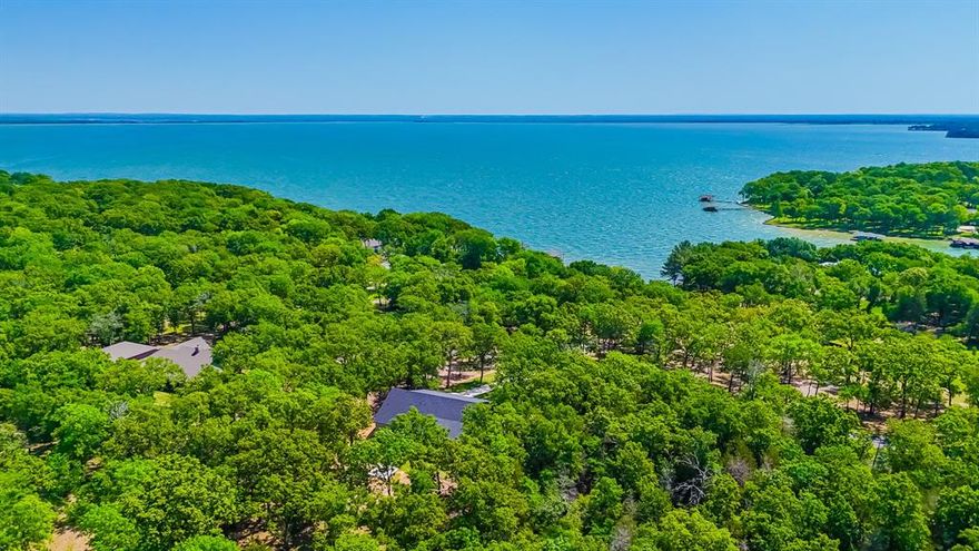 This stunning newly built home with rear lake access is situated in the highly sought after Wilderness Subdivision, offering peaceful water access right in the backyard. Surrounded by towering trees and abundant wildlife, including freely roaming deer, it offers a peaceful retreat from the everyday. The home offers a modern design, quality craftsmanship, and luxurious finishes throughout. Featuring an open concept layout, the spacious living and dining areas are filled with natural light, highlighted by soaring 18-foot ceilings. The gourmet kitchen is equipped with sleek granite countertops, custom modern cabinetry, stainless steel appliances, and a large island. There is also a butler’s pantry and a dry bar which is perfect for entertaining or everyday use. The primary suite is a true haven, featuring a spa like ensuite with a soaking tub, separate shower, double vanity, and two large walk-in closets. Two additional spacious bedrooms provide comfort for family or guests, while a versatile bonus room adapts to your needs, could be used as a 4th bedroom, media room, or game room. One bedroom even serves as a second primary with its own ensuite. Upstairs, a private guest suite that has space for a kitchenette, laundry, full bath, and walk-in closet. Step outside to enjoy the screened in patio and covered back porch, where you can take in the peaceful surroundings. The backyard features a fire pit, ideal for unwinding under the stars. With water access just steps away, this home is perfect for lake lovers seeking both relaxation and adventure. Don’t miss the opportunity to make this lake house your own!