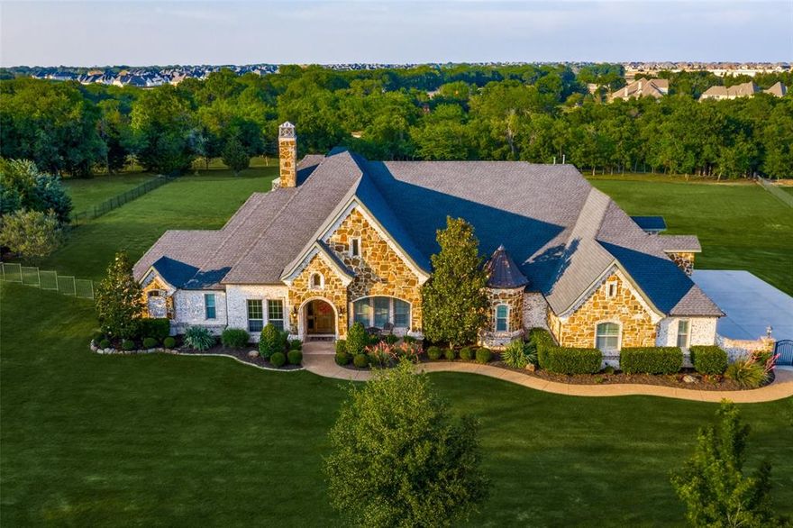 WELCOME HOME!  Exceptional One Story Home is Situated on 2.73 Acre Creek Lot.  Gorgeous hardwoods throughout. Kitchen hosts a large island, Viking convection double ovens & appliances. Sub Zero fridge, pot filler, exotic granite & breakfast bar. Open to a family sized breakfast nook & living rm w walls of windows overlooking the exceptional outdoor living area. Primary bedrm offers dbl crown molding, luxurious bath, huge WI closet w built-ins. Office has built-ins & closet. Large dining room w butlers pantry & wine fridge. Large secondary bedrms each w full baths. Media rm, separate utility rm w sink, built-in cabinets & mud bench.  Outdoor oasis w heated pool & spa, wood ceiling, commercial grill, fireplace & bar surrounded by thick trees, overlooks your own private paradise and creek lot. Unfinished walk-up stairs attic space could be game room. Approx 600sf. 4 Car oversized garage w extra parking behind gated driveway.  Highly desirable Prosper ISD zoned for the new Walnut Grove HS.