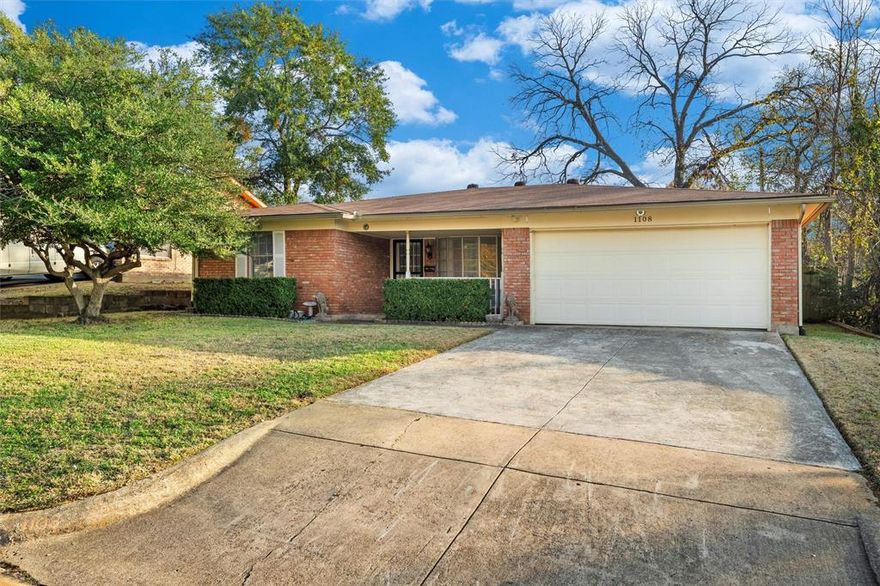Vacant and move-in ready, this home offers convenient access to Downtown Fort Worth, I-30, DFW Airport, and President George Bush Turnpike. The kitchen features granite countertops, tumbled tile backsplash, custom cabinetry, a breakfast bar, and ample counter and storage space. Just off the kitchen are two distinct living areas—one highlighted by French doors that open to the spacious backyard, and the other featuring a large window overlooking the front porch. The primary suite includes a private ensuite bath with an updated shower. Secondary bedrooms provide generous floor space and storage. Enjoy outdoor living in the expansive backyard with a covered patio, perfect for relaxing or entertaining. Additional highlights include tile flooring throughout the main areas, updated light fixtures, and upgraded finishes in both bathrooms.
