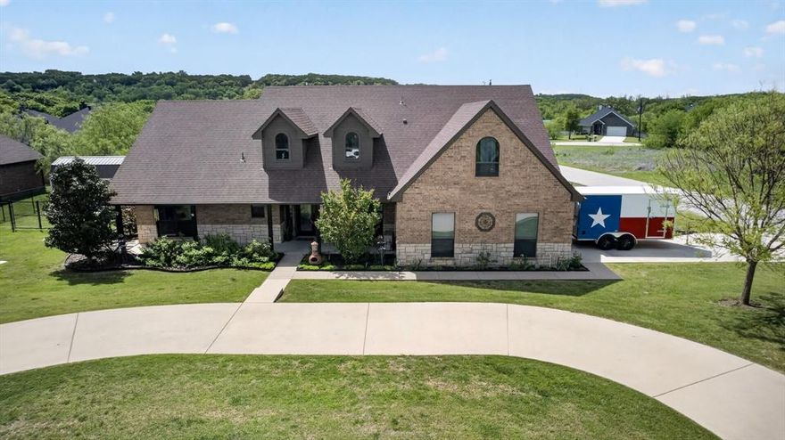 Exceptional outdoor living on nearly half an acre, oversized storage, and RV ready parking set this beautifully maintained 4 bedroom corner lot home apart from newer options nearby. Just 15 minutes from door to shore at Benbrook Lake, this thoughtfully designed property offers the space, flexibility, and functionality buyers in this area are searching for.

A 40 foot covered front porch stretches across the entire front of the home, while the oversized rear covered patio creates the perfect setting for entertaining, grilling, and peaceful Texas evenings. Native landscaping, established younger trees, and attractive taller black chain link fencing provide a polished outdoor setting that still feels open and highly usable.

Two separate drive approaches include a circular front drive plus side entry garage access, creating excellent guest parking and ideal space for RV, boat, or trailer parking.

Inside, updated flooring completed within the last two years complements the spacious layout. The upstairs bonus room adds valuable flex space for hobbies, kids, a playroom, office, or even more storage. Storage is truly exceptional with generous closets, a large attic, and oversized 10 x 20 storage shed.

The side entry garage includes its own mini split plus an upgraded 100 amp subpanel with dedicated 220 and 120 circuits, making it ideal for projects, workshop use, hobby space, or climate controlled flex living.

This home offers the lot functionality, storage capacity, and outdoor lifestyle features that are becoming harder to find in newer homes nearby.
