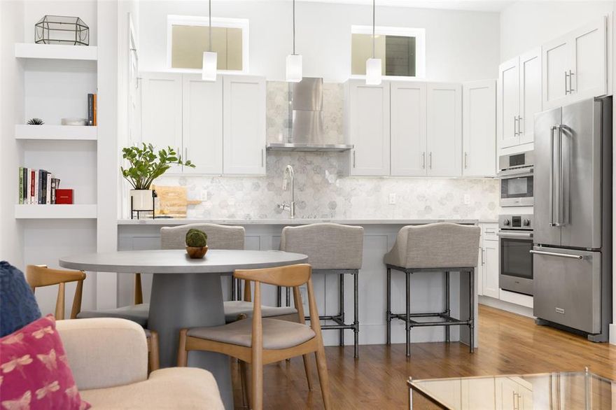This sophisticated townhome-style condo combines designer style with the ultimate urban location. The first floor offers a flexible bonus room, perfect for a home office, workout room or creative space — plus access to a private fenced yard and the convenience of an attached two-car garage.
Upstairs, the airy open-concept layout is built for entertaining. A spacious living and dining area with tall ceilings and gorgeous wood floors flow seamlessly into the show-stopping kitchen and out to the spacious balcony. Quartz countertops, a marble backsplash, high-end appliances, and a generous island make the kitchen perfect for gathering with friends. The third floor is a private retreat with two large bedrooms, both with en suite baths. The luxurious primary suite features a spa-worthy oversized shower, and a walk-in closet. The upstairs laundry room adds an extra layer of convenience. Located less than a mile from Baylor Medical Center and minutes from Downtown, Uptown and Lower Greenville, this home puts Dallas’ best dining, nightlife, and culture just steps away — all while offering a low-maintenance, lock-and-leave lifestyle.