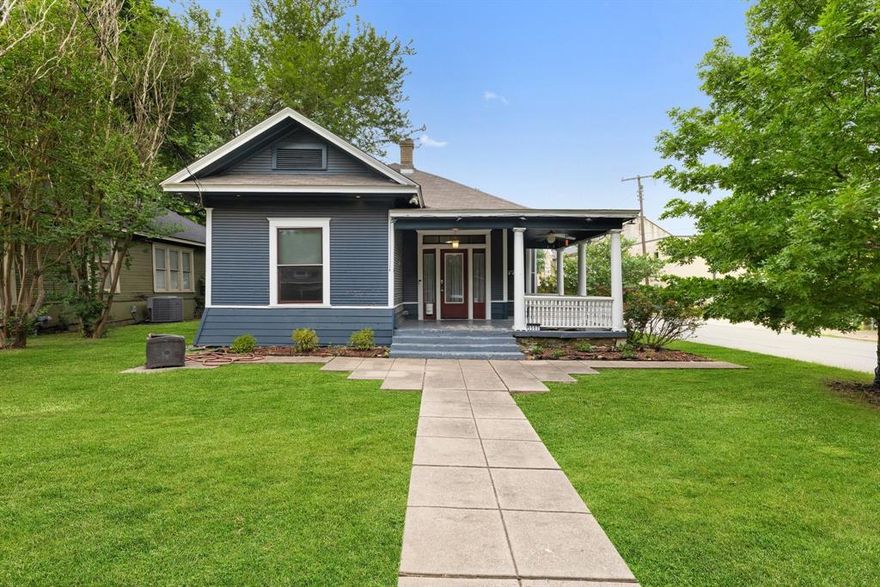 Step into timeless elegance with this beautifully preserved 1912 Craftsman home, ideally situated on a tree-lined street in the highly desirable Junius Heights Historic District. This 3-bedroom, 2-bath residence effortlessly combines classic architectural charm with thoughtful modern updates. From the moment you arrive, the home's striking deep blue exterior, white trim, and expansive wraparound porch with stately columns create a welcoming first impression. Inside, soaring ceilings and original hardwood floors flow throughout the spacious layout, while natural light pours in through tall windows, highlighting the historic trim and picture rail detailing. The open living area transitions seamlessly into a stylish, updated kitchen featuring warm wood cabinetry, stainless steel appliances, a gas range, tiled backsplash, and a breakfast bar with pendant lighting—perfect for everyday living and entertaining. Each bedroom offers generous space and period character, while both bathrooms have been beautifully renovated with modern fixtures and finishes that respect the home’s vintage integrity.