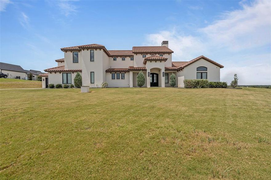 Set on an elevated 3.35-acre lot with panoramic views, this stunning 6,203 SF home is located in the prestigious gated La Madera community and within sought-after Aledo ISD. Offering 4 bedrooms, 6 full baths, and 1 half bath, the residence blends clean architectural lines with warm, livable design.The open-concept floor plan showcases a dramatic living, dining, and kitchen area with soaring ceilings, statement lighting, and walls of glass that frame expansive views. The chef’s kitchen features custom cabinetry, a center island, and seamless flow into the living spaces—ideal for entertaining. The first floor includes a spacious game or family room, guest suite, and the private primary suite with spa-style bath. Upstairs, a sitting area leads to two ensuite bedrooms and a media or game room. An attached guest suite on the main level offers privacy while remaining connected, complete with open living space, built-in cabinetry, and a full bath—perfect for extended stays or multi-generational living. Outside city limits, this property offers both privacy and lifestyle flexibility in one of the area’s most desirable gated communities. Property is being sold AS IS. Inspection and engineering reoprt available.