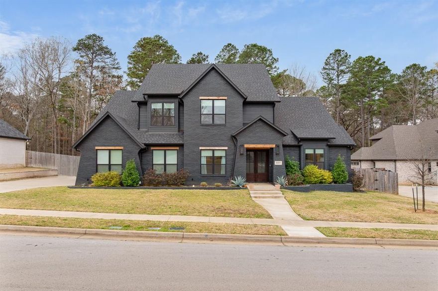 Stunning home in gated Caddo Ridge Estates! This home is a whole vibe, with the bold exterior color and chic modern touches throughout the interior. The living area has tall ceilings, a sky-high fireplace, and stylish focal wall. The kitchen is every cook's dream with a large island workspace, SubZero fridge, 6-burner gas range, double ovens, KitchenAid appliances, and walk-in pantry. Work from home with ease at the built-in office space. Enter through the side door or garage into the mudroom where you'll find built-in cubbies to drop your bags, shoes, and jackets. Dreamy primary suite with spa-like en suite bathroom (dual vanities, soaking tub, walk-in shower, water closet, and more!) and massive walk-in closet. One guest room downstairs is an ideal mother-in-law suite with a nearby bathroom. Upstairs there's an open flex space at the top of the stairs that's perfect for a reading nook, gaming table, or additional living space. One of the upstairs guest rooms has an en suite bathroom, while the other two upstairs guest rooms share a hall bath. Enjoy relaxing on your large covered back porch, complete with fireplace. A greenbelt runs along the back fence, giving you extra privacy. The South Tyler location is convenient to shopping, dining, and entertainment--including the Cumberland Mall and the upcoming Parkside Development. Tyler address, WISD schools!