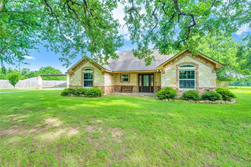 Welcome home to this stunning custom-built property where charm, craftsmanship, and peaceful country living come together perfectly. Towering mature trees line the front yard, creating a breathtaking plantation-style entrance and an unforgettable first impression. Inside, attention to detail is evident throughout the home, with high-end finishes, thoughtful design elements, and a warm, inviting atmosphere. The spacious kitchen is a dream for entertaining and everyday living, featuring a huge walk-in pantry, abundant cabinet space, double ovens, and a new cooktop. Both bathrooms showcase elegant marble countertops and marble shower surrounds, adding a touch of luxury throughout the home. The split-bedroom floorplan offers added privacy, while all of the windows provide tranquil views and fill the home with natural light and peaceful scenery. Step outside to the massive covered back porch, designed for relaxing and entertaining alike. With ample space for a hot tub, outdoor kitchen, porch swings, and more, the possibilities for creating your ideal outdoor retreat are endless. The detached garage workshop with attached carport is truly a dream space, offering plenty of room for hobbies, storage, vehicles, or projects. Enjoy the serenity of country living while still being conveniently close to town. Surrounded by nature and peaceful views, this property offers the perfect balance of privacy and accessibility. Looking for multi-generational living or additional acreage? The neighboring property is also available, and the sellers may consider a discount for buyers interested in purchasing both properties together.