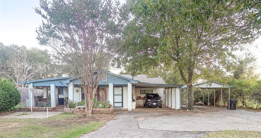 Country feel, minutes from town, with room for all your people, pets, & projects. Behind the gated entrance, crepe-myrtle-lined drive, this 3-bedroom, 3-bath home on roughly three-quarters of an acre sits outside city limits, so you can enjoy space and privacy without city taxes. Imagine coming home to shade trees, big Texas skies, & the quiet of nearby horses & cattle—then being in Mineral Wells in just a few minutes. With both attached & detached covered parking, there’s room for multiple vehicles, a boat, or a work trailer, plus a fenced backyard, storage shed, & dog run for pets or projects. The layout works beautifully for anyone wanting a little elbow room without giving up convenience. Inside, an oversized living room and wood-burning fireplace create a cozy gathering spot for holidays, movie nights, or game days. The kitchen overlooks the backyard so you can watch nature while you cook, & the large laundry room offers space for full-size appliances, pantry storage, & a drip-dry area—ideal for work clothes or muddy play clothes.  The primary suite is a true retreat with a generous sitting area, built-in shelving, walk-in closet, and walk-in shower, giving you a quiet place to unwind at the end of the day. On the opposite side of the home, a second bedroom with its own ensuite bath is perfect for guests, or multigenerational living, while the third bedroom is flexible enough to serve as an office, hobby room, or nursery. Step out to the covered patio with a built-in grill and you’ve got an instant spot for cookouts, morning coffee, or evenings under the trees. The combination of multiple carports, storage, & outdoor space makes this property a great fit for people who need extra room for tools, toys, or a small home-based business. If you’ve been looking for a comfortable home with a country feel, usable outdoor space, and no city taxes—just minutes from town—this property deserves a spot at the top of your list.