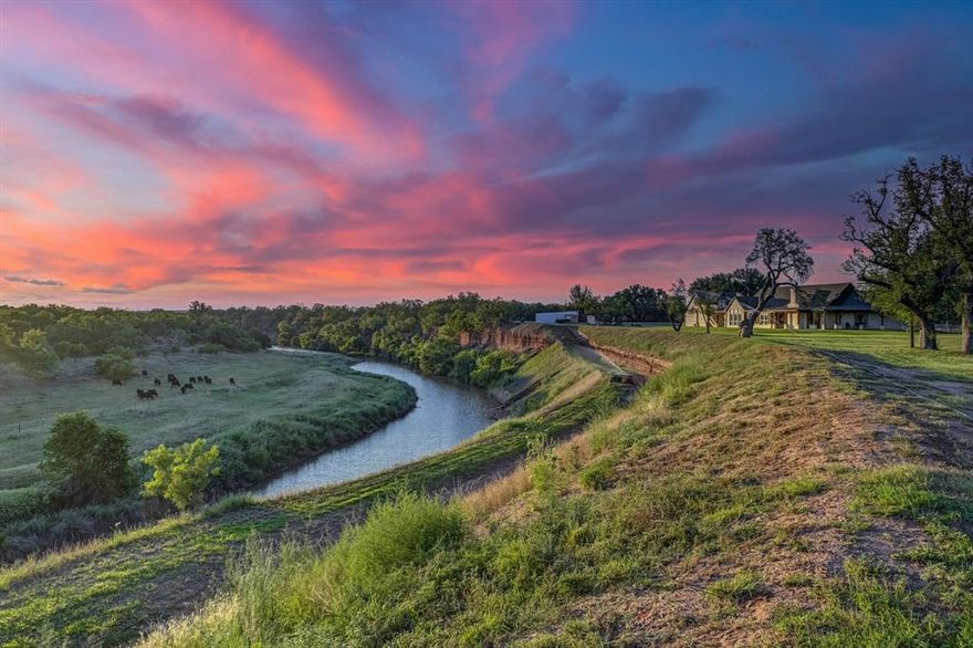 This rare Texas Live Water river ranch blends luxury living w outdoor recreation on approx 515.93 acres & approx 2.8 miles of Colorado River frontage, just 30 min S of Brownwood and 2.5 hrs E of Ft Worth. Paved county road leads to a private gated entry, where heritage oaks guide you to the main residence: 3 bedrooms, 2.5 baths, office, formal dining, oversized laundry, & game room w bar, shuffleboard & stools, all conveying. A 1-bd, 1-ba garage apt and separate 2-bd, 2-ba hunter’s cabin provide additional residences. A wide wraparound porch captures sunset views over the Colorado River. The chef’s kitchen features granite countertops, dbl ovens, 5 burner cooktop, custom cabinetry & oversized walk-in pantry. The living room features high ceilings, crown molding and white stone fireplace. The primary suite has cathedral ceilings w exposed beams, spacious bath & steel-door walk-in closet for added security.

The updated hunter’s cabin includes a large living room, 2 fireplaces, full kitchen w SS appliances, 2 dining areas and game room w bar, shuffleboard & wall games—all conveying. Also washer dryer room, mudroom & storm cellar just steps away. Firepit & BBQ smoker convey.

Designed for recreation and operations, the ranch offers a 150-yd shooting range w pro targets, fishing, canoeing, hunting & boating. Five deer blinds & feeders strategically placed throughout the property. Infrastructure includes 2 barns, storage bldgs, cattle squeeze chute, horse corrals, tack rm w AC & heat, deer cleaning station, 3 kennels & RV hookups (50 25 amp w water & sewer). Property is served by community water, 2 wells & river pump w irrigation spigots. High-speed fiber optic internet available at both homes. Majestic oaks, pecans & mesquites line ranch roads leading to the river’s edge. This ranch offers the ideal mix of luxury, recreation & operational capacity, perfect as a private retreat, family estate or working cattle equestrian property.