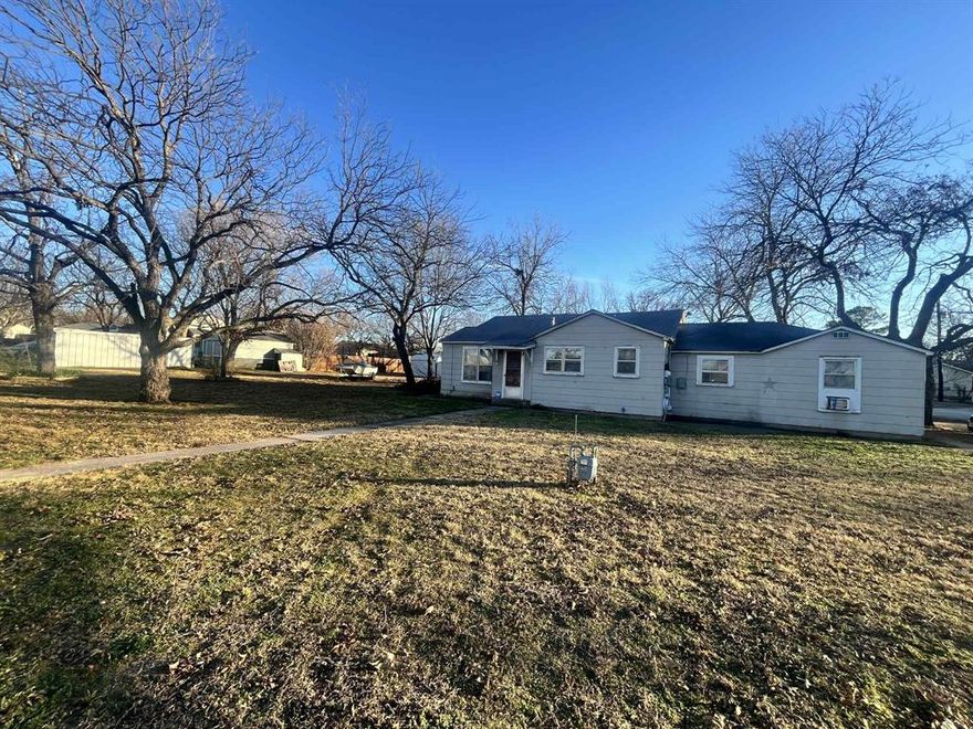 Charming three-bedroom, two-bathroom residence requiring some renovation, boasts an efficient layout with ample storage solutions. Spacious bedrooms feature generous closet space, while the functional kitchen offers extensive counter space and cabinets for additional storage needs. A cozy living area accommodates furniture comfortably and seamlessly integrates with the kitchen, fostering a sense of togetherness. The oversized carport ensures effortless entry and exits from the home, shielding vehicles from inclement weather. A fenced yard provides a safe haven for children and pets, while three spacious lots offer ample room for entertainment. Furthermore, the property includes four storage units ideal for outdoor equipment, seasonal decorations, and lawn care supplies. Strategically situated on a picturesque corner adorned with pecan trees, this property is conveniently located near local amenities, including restaurants, dollar stores, churches, and schools. This gem is perfect for discerning buyers seeking a project with immense potential; we encourage interested parties to schedule a viewing. More pictures to come soon!