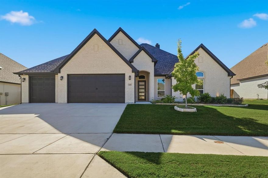 Discover elegance and ease in this exceptional one-story residence nestled in the coveted Spring Ranch Estates community, zoned for the renowned Northwest Independent School District. Located at 1441 Rocky?Springs Trail in Haslet, this 4-bed, 3.5-bath home spans 2,682 sqft of refined living space. The open-floor plan is anchored by a spacious great room with high ceilings and oversized windows, flowing seamlessly into the chef’s kitchen featuring crisp white cabinetry, premium quartz countertops and a stainless-steel farm-style sink. The suite wing boasts a separate bedroom and full bath—ideal for in-law accommodations or a private guest retreat—while 2 additional bedrooms offer flexibility for family, office or hobby space. The primary suite is a relaxing retreat with coffered ceiling and exposed beams and a spacious en-suite with granite counters, gorgeous tub, shower for two, a HUGE walk-in closet with direct access to the laundry room! Premium details include wood-look tile flooring for low-maintenance durability, an epoxy-coated floor in the three-car garage, and a covered patio with a built-in propane hookup perfect for outdoor grilling and entertaining and the kitchen is plumbed for this as well so you could easily add a gas cooktop! The large backyard, complete with a shed and jungle gym, provides the perfect setting for kids, pets or a future pool. Positioned just minutes from major highways for easy commuting, and within reach of shopping, dining, greenbelts, lake recreation and walking trails, you’ll enjoy both convenience and community. With smart-design functionality, modern finishes and a standout location, this home presents a rare opportunity to move in and thrive.