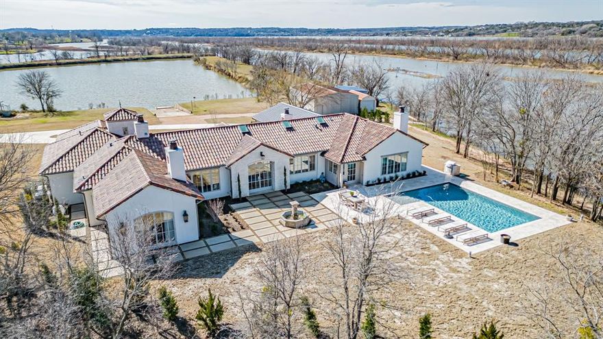 European inspired country French estate on the most unique waterfront acreage on Lake Granbury.  Just completed November of 2022, the home's antique beams, repurposed doors, European fireplace mantels and light fixtures add to the timeless architectural statement.  Large windows allow viewing water from every room in the house.  The pale pallet of Austin Stone and diamond coat plaster walls and ceilings make it light, bright and inviting.  Every detail in this home was intentionally selected and no expense was spared.  There is a newly remodeled 2 bedroom, 2 bath guesthouse, 2 docks, a swimming pool, 2 shops, and a fire pit by the water for a truly must see property. The home is a designer's dream styled after Patina Farms of CA complete with imported Greek fountain in the Lueders limestone courtyard.  There is over a mile of shoreline, tranquil seclusion, wildlife, a privacy gate, concrete driveway and it is just unlike anything else in Granbury, TX. See Features in Supplements
