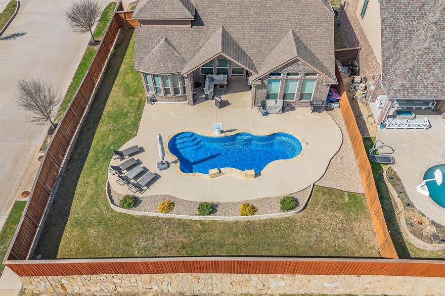 Welcome to your spacious retreat in Morningstar, located in the highly sought-after Aledo ISD. Situated on a large corner lot with an elevated position, this home offers a level of privacy that’s hard to find. Step outside to your own backyard escape—complete with a gas-heated pool and expansive deck, perfect for year-round enjoyment and entertaining. Inside, oversized windows flood the home with natural light while showcasing views of the pool and surrounding landscape. The kitchen blends style and function with white quartz countertops, rich wood cabinetry, a farmhouse sink, and designer pendant lighting—creating a space that feels both timeless and inviting. Wood-look tile flooring throughout the main living areas and bathrooms offers durability and easy maintenance, ideal for everyday living. Upstairs, one of the bedrooms has been thoughtfully converted into a private ensuite, offering flexibility as a second primary suite or guest retreat. Living in Morningstar means access to resort-style amenities, including two pools, an amenity center, basketball court, soccer field, fishing ponds, dog park, and a full-time Lifestyle Director coordinating events throughout the year. This home offers the perfect blend of space, functionality, and community living—with a layout and setting that truly stand out.