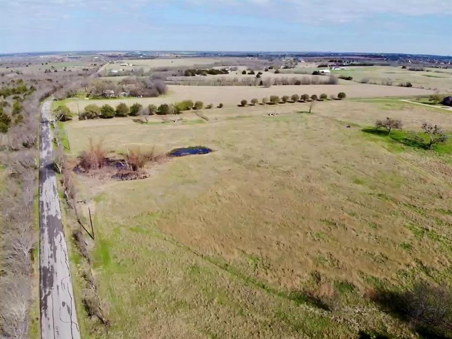 Discover the potential of country living with this unique 30 acre opportunity just outside Ennis, Texas. This offering includes two separate parcels being sold together, resulting in roughly 1950 feet of road frontage. These two parcels combine a homesite with expansive agricultural land and provides endless possibilities for rural living, investment, or future development. The first parcel consists of approximately 2 acres and includes an existing home structure & barn that currently will require significant renovation or removal. This portion of the property offers an excellent homesite with space to rebuild, design a custom residence, or create a private country retreat surrounded by open land. The second parcel features approximately 28 acres with an unmaintained pond, currently designated as agricultural land & used for hay production. The open acreage offers flexibility for a variety of uses including livestock, farming, recreation, or simply enjoying the privacy and space of rural Texas property. Located just minutes from downtown Ennis, the property offers the quiet and freedom of country living while maintaining convenient access to local shops, dining, schools, and major highways connecting to Waxahachie, Corsicana, and the Dallas–Fort Worth area. The property is also uniquely positioned minutes from Ennis Municipal Airport, the legendary record setting Texas Motorplex, & lakes Bardwell & Clark. With approximately 30 acres across two parcels, this property presents a rare opportunity to create a private homestead, establish agricultural use, or invest in land in the growing Ellis County area. Buyer to verify utilities, zoning, and development possibilities. Schedule showings through SupraOne & enter overgrown property at your own risk.
MLS#21200113 & MLS#21199814 (Parcel #190369 & #190368) to be sold together.