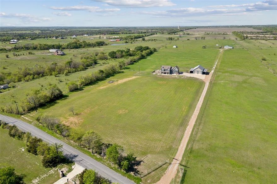 Experience wide-open Texas living without sacrificing luxury — a rare blend of flexibility and refinement on 11 ag-exempt acres just minutes from charming downtown Van Alstyne. At the heart of it all is a thoughtfully remodeled two-story home, extensively renovated seven years ago under one contractor. Updates include Hardie board siding, fresh paint, and Infinity® Ultrex® windows — known for their strength and durability that outlast traditional vinyl. Inside, you'll find oversized rooms filled with natural light, a chef’s kitchen with a WOLF range, built-in fridge, wine storage, and custom cabinetry.

Off the mudroom, a built-in storm shelter adds peace of mind for safety or storage. The primary suite offers a true retreat, with a private sitting area featuring custom built-ins — ideal for a reading nook, home gym, or lounge. Vaulted cedar tongue-and-groove ceilings with recessed lighting and a spa-like ensuite with garden tub, seated shower, and dual closets complete the space.

Outside, the lifestyle continues. The oversized 2-car garage is joined by a fully insulated 35x54 workshop with two carports — perfect for storage, hobbies, or business. A separate storage building adds even more utility, with electricity and water already in place. Modern comforts include full spray foam insulation, a smartphone-controlled HVAC system, propane-powered instant hot water, and a newly replaced hail-resistant roof (insurance discounts apply). The septic system is professionally serviced three times annually and includes an alarm. Termite protection and concrete pest barriers offer additional peace of mind. Whether you’re homesteading, hosting, or simply seeking room to breathe, this one-of-a-kind property is a true North Texas gem.

Looking for more land? Additional acreage is available — inquire for details.