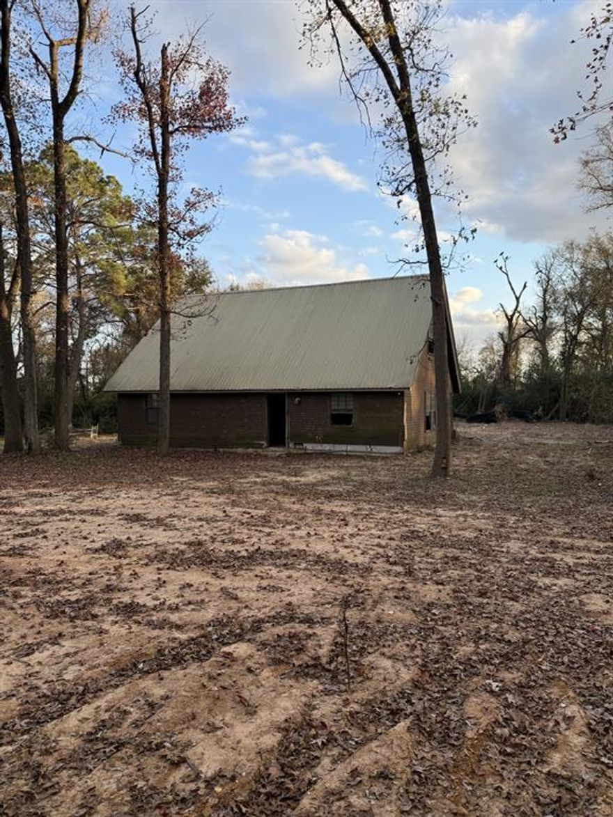 6.6 acres (TBD by Final Survey) More or less land is available. House has its own meter box at the highway, just needs a reconnect. New Power is brought in from the back side of the property. There is a Shop with electric but will need the meter installed. House is solid but will need full renovation. Property is lined with mature Oaks, Pines, Hickory, Pecan and various other trees. Would be a fabulous place once fixed up and price reflects this.