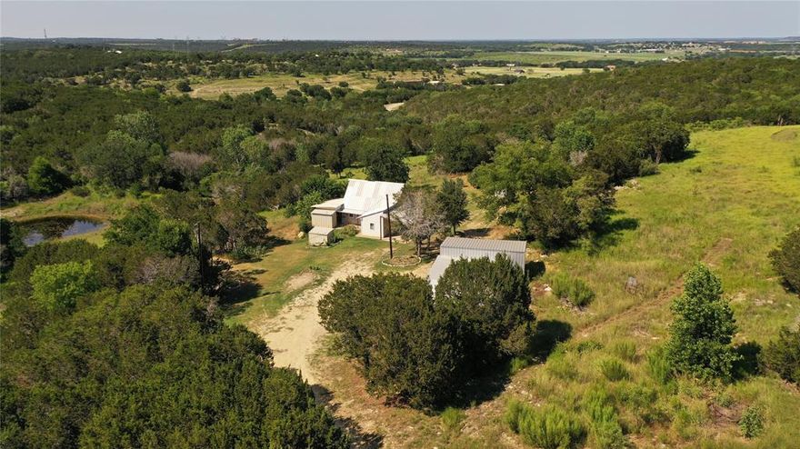 This property may have the Hilltop Building Site with the Stunning View you've been looking for. 11.97 acres which has been mostly cleared and is fenced. Hilltop building site offers a spectacular view all the way to Comanche Peak. Small 2-story fixer-upper home which could be used for weekends while you build your new home. The residence could be renovated for a nice little guest house. Nice sized pond on the property just below the home. Several outbuildings including a large 1440 sq. ft. equipment shed with RV Carport, a second 800 sq. ft. equipment shed, small workshop and cattle pens. Water well on property, but County Water service is available at the property entrance.
