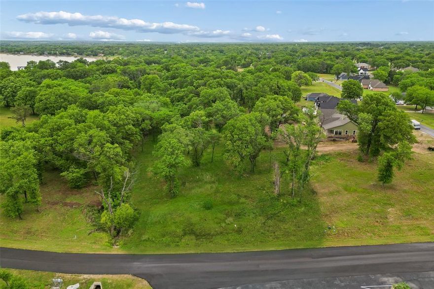 Discover the opportunity to create your ideal retreat on this beautifully positioned vacant lot with lake views in the exclusive gated community of Cedar Creek Landing. Spanning approximately 0.84 acres, this homesite features mature, shaded trees and a prime location across from the lake, community pool, and clubhouse—offering both convenience and scenic surroundings. Enjoy peaceful water views and stunning sunsets from your future residence, all within an easy commute to Dallas. The community is thoughtfully designed with paved roads, installed utilities, and fiber optic connectivity, providing a strong foundation for modern living. Cedar Creek Landing offers a variety of amenities to enhance your lifestyle, including an infinity-edge pool, clubhouse with fitness center, outdoor grilling areas, and a private marina with additional boat docks for guest access. Residents can also enjoy the stocked community pond, creating additional outdoor leisure opportunities. For those who enjoy golf, Cedar Creek Country Club is located nearby and accessible by golf cart with membership options available. The surrounding neighborhood showcases well-appointed homes and a welcoming atmosphere, making it an ideal setting for a primary residence or a relaxing weekend getaway. Bring your vision and build a space that fits your lifestyle in this desirable lakeside community.