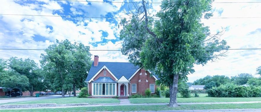 Nestled on a sprawling corner lot with towering trees, this stunning 2-story, red brick home built in 1926 blends timeless charm with modern upgrades. Boasting 3461 sq. ft. of living space, this unique residence features three bedrooms, three bathrooms, and a wealth of thoughtful details throughout. Step inside to find soaring ceilings, a formal living room with a cozy fireplace, and a spacious den with a second fireplace, complemented by gorgeous terrazzo tile floors and built-ins. The wet bar adds an element of convenience and sophistication, perfect for entertaining. A large formal dining room sets the stage for intimate dinners, while the expansive kitchen is a chef's dream, offering a walk-in pantry, double ovens, an electric cooktop with vent, ample counterspace and direct access to the backyard via a sliding door. The oversized master suite is a true retreat, offering a private sitting area, three closets, and a sliding door that leads to the backyard. The en-suite master bathroom features two separate vanity areas, ample built-ins, more closets, and a separate tub and shower for ultimate relaxation. A guest bedroom and full bath are conveniently located on the main floor, while another guest bedroom with a full bathroom is located upstairs, ensuring privacy for all. The home also includes an inside utility room with double sinks, cabinetry, and space for a freezer, with easy access to the backyard. Outside, enjoy a vast fenced backyard with a large patio, perfect for entertaining, plus a sprinkler system for easy maintenance. Additional amenities include a two-car garage with an attached two-car carport, an equipment shed, and attached guest quarters for added convenience. Recent updates include a new roof and gutters in 2024. This home blends historical elegance with functional features, offering the perfect space for both family living and entertaining. Priced to reflect repairs needed, especially foundation issues. With a little TLC, the home will shine!