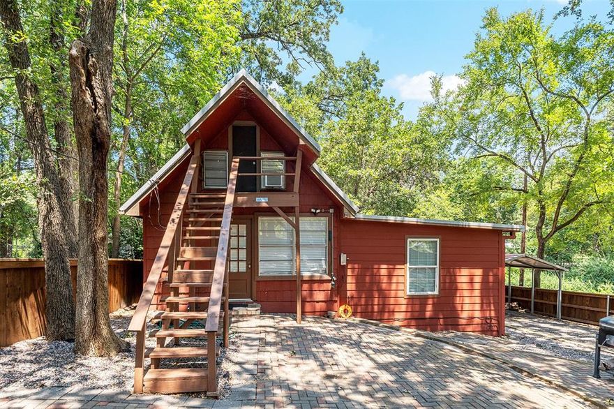 Cute and cozy Cabin currently being used as a short term rental .  With the updated modern features in this quaint property its the perfect property to use as a week end get away or continue as a short term rental..The large out door space with private fence allows for get togethers or taking in the quiet park like space and enjoy nature.  Included on the property is a one car car port and storage building... The indoor features a large bedroom ,
kitchen and dining and bath..updated to the modern style. The second bedroom is entered from the outside and on the second floor as a loft style bedroom.  Property is rented frequently and could also be rented long term.  Located close to the lake, boat ramp access in the neighborhood is available.