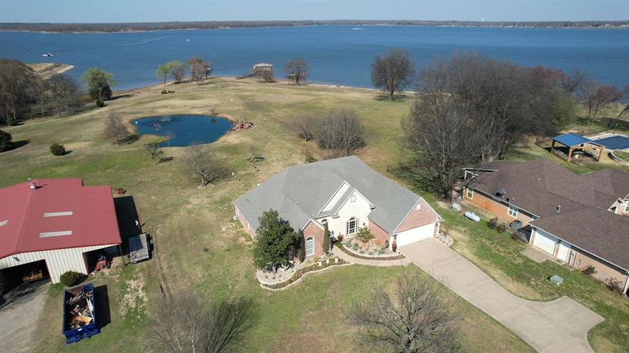 Discover your East Texas waterfront dream home on legendary Lake Fork. Famous for world-class fishing and breathtaking lake views. This beautiful 2,387 sq ft brick and stone home sits on 2.78 acres plus leaseback, offering plenty of space (4 bedrooms - 2 baths; one bedroom being used as office), privacy, and direct access to the water from your oversized single slip boathouse. Inside, you’ll find a thoughtfully designed 4B & 2B layout with room for both relaxing and entertaining. The cozy gas fireplace anchors the living room, creating the perfect gathering space after a day on the lake. Enjoy working from home in the dedicated office, host guests in the formal dining room, and start your mornings in the breakfast area with scenic views of the property and water. One of the home’s standout features is the glass-enclosed sunroom, where you can unwind while taking in the stunning East Texas sunsets over the lake. Outside, the property truly shines. A 25-foot deep pond adds charm and additional fishing opportunities, while the impressive 32×60 shop with 12-foot overhangs on both ends provides abundant space for toys, tools and projects. With plenty of storage and room to roam, this property is ideal for full-time living or a weekend getaway. All of this is located within convenient reach of the Dallas–Fort Worth Metroplex, making it easy to enjoy lake life while staying connected to the city. Don’t miss this rare opportunity to own a waterfront property on Lake Fork. Schedule your private showing today and experience East Texas lake living at its finest!