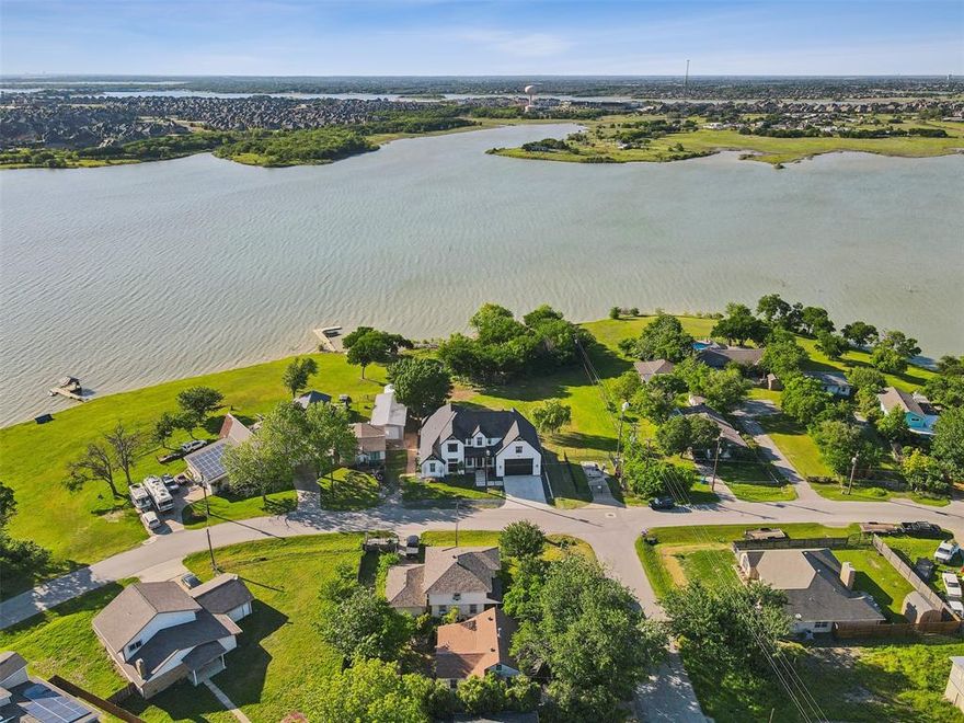Lakefront dream property on Lake Lewisville! Home custom built by the desireable team at Our Country Homes, perfectly positioned for enjoying sunsets on the lake. Designed with family and entertaining in mind the large kitchen opens up freely to the dining and living area and then flows right outdoors to the all-season patio equipped with heaters, fans and a fireplace for comfortable enjoyment of the lake life even when it is cold! The two bedrooms on the main floor have a Jack and Jill bath, with an option to use one bedroom as a media room instead. Upstairs features 3 additional bedrooms all with en suite baths and plenty of extra build out space if needed! Back yard is a nice flat and grassy space perfect for backyard play and a future pool. Not to be overlooked is the overbuilt garage that can accommodate two ski boats! Come get away and relax in this true active lake community, with friendly neighbors, no HOA, all just 18 minutes from Frisco and 20m to DFW airport.