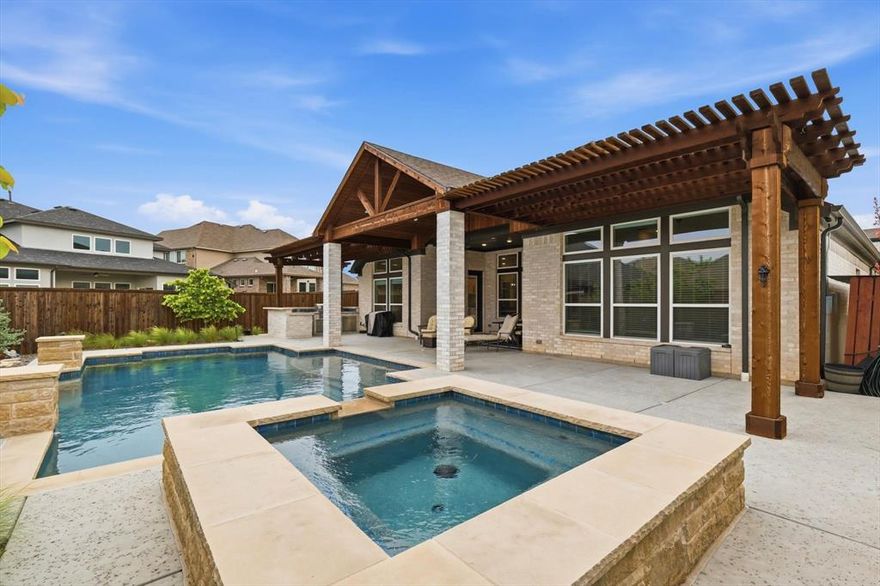 Welcome to a home that's designed not just to be lived in, but truly enjoyed. Nestled in the highly sought-after Canyon Falls community, this stunning one-story residence sits on an oversized lot and offers the perfect blend of comfort, style, and effortless entertaining. From the moment you step inside, you’re greeted with a sense of openness that immediately feels like home. With 2,764 square feet, a flexible floor plan, and a 3-car garage, there’s room here for everyone to spread out while still staying connected. The heart of the home is the sun-drenched family room, where walls of windows frame views of your sparkling pool, setting the stage for endless summer memories. This inviting space flows seamlessly into the eat-in kitchen and dining area, creating the perfect backdrop for everything from casual mornings to lively gatherings. Designed with beauty and function in mind, the kitchen is a dream for any home chef. Featuring a dramatic waterfall island, SS gas appliances, and a spacious wine or beverage fridge, it’s ready for everything from weeknight dinners to hosting friends and family. The owner’s retreat offers a true escape, inviting you to relax and recharge, complete with a spa-like ensuite featuring a luxurious walk-in shower, dual sinks, and generous storage. The oversized walk-in closet is just the cherry on top. The thoughtful layout continues with a versatile bonus room~media room plus a dedicated office—perfect for working from home, hobbies, or accommodating guests with ease. Your backyard oasis is built for Texas living, featuring a covered patio, outdoor kitchen, and a beautiful pool that turns every day into a staycation. Living in Canyon Falls means more than just owning a beautiful home, it’s a lifestyle. Enjoy access to resort-style amenities including the community pool, clubhouse, fitness center, miles of scenic trails and parks. This is the kind of home where memories are made, laughter is shared, and life feels just a little bit easier